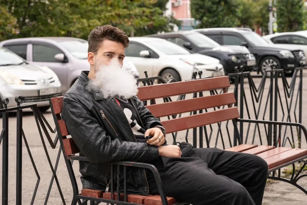 Persona usando un cigarrillo electronico en la calle- clinica de insuficiencia cardiaca